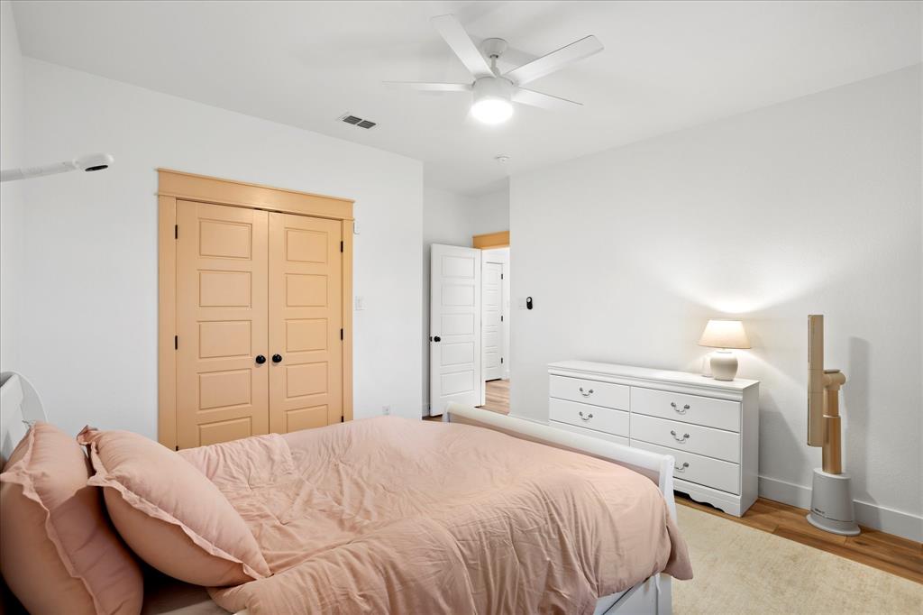 1074 Pioneer Crossing Weatherford, TX 76088 - Photo 29 of 36 a bedroom with a bed and a chandelier