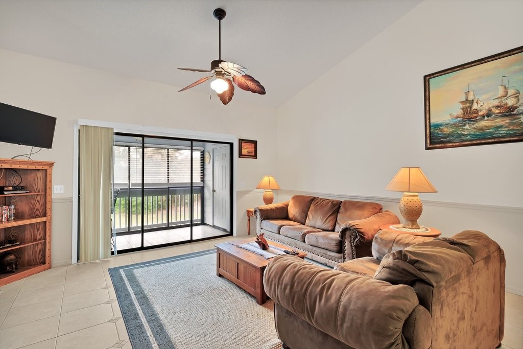 9637 Riverside Drive, Unit 3 Sebastian, FL 32958 - Photo 6 of 36 a living room with furniture a large window and a flat screen tv