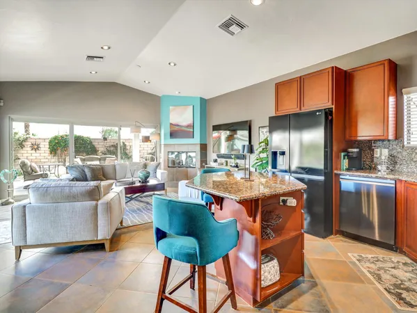 a kitchen with kitchen island granite countertop a sink a counter top space cabinets and a couch