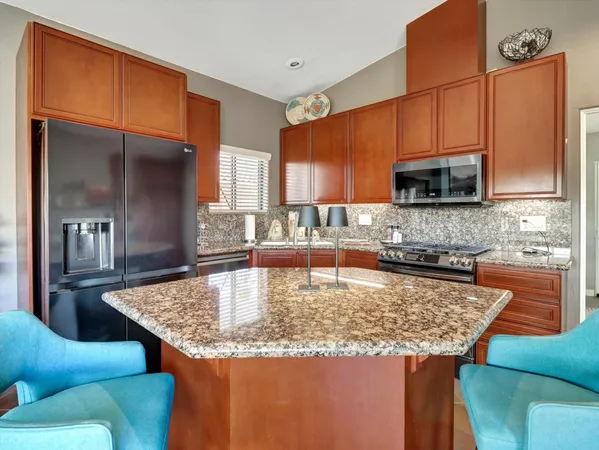 a kitchen with stainless steel appliances granite countertop a stove and a refrigerator