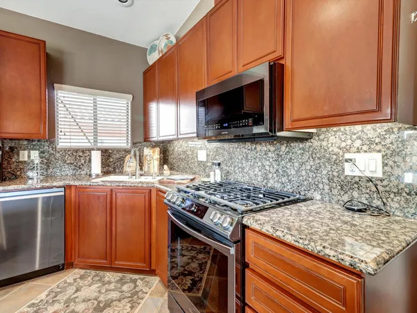 a kitchen with stainless steel appliances granite countertop a refrigerator and a sink