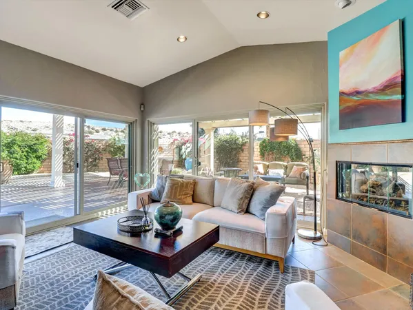 a living room with furniture potted plant and a large window