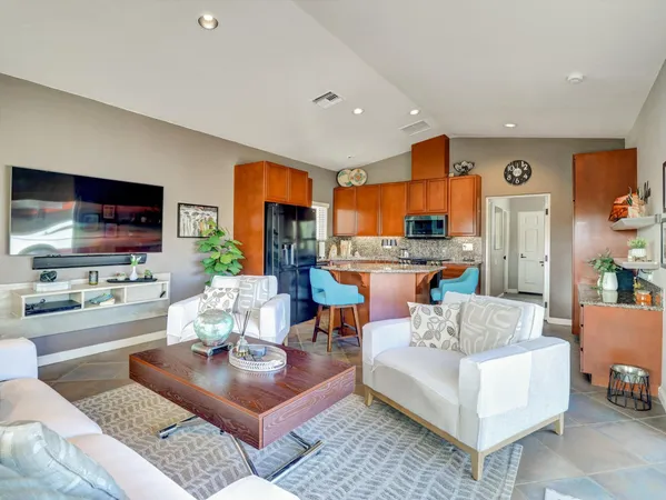 a large living room with stainless steel appliances kitchen island granite countertop furniture and a kitchen view