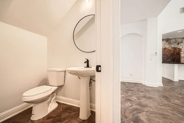 a bathroom with a toilet sink and a mirror
