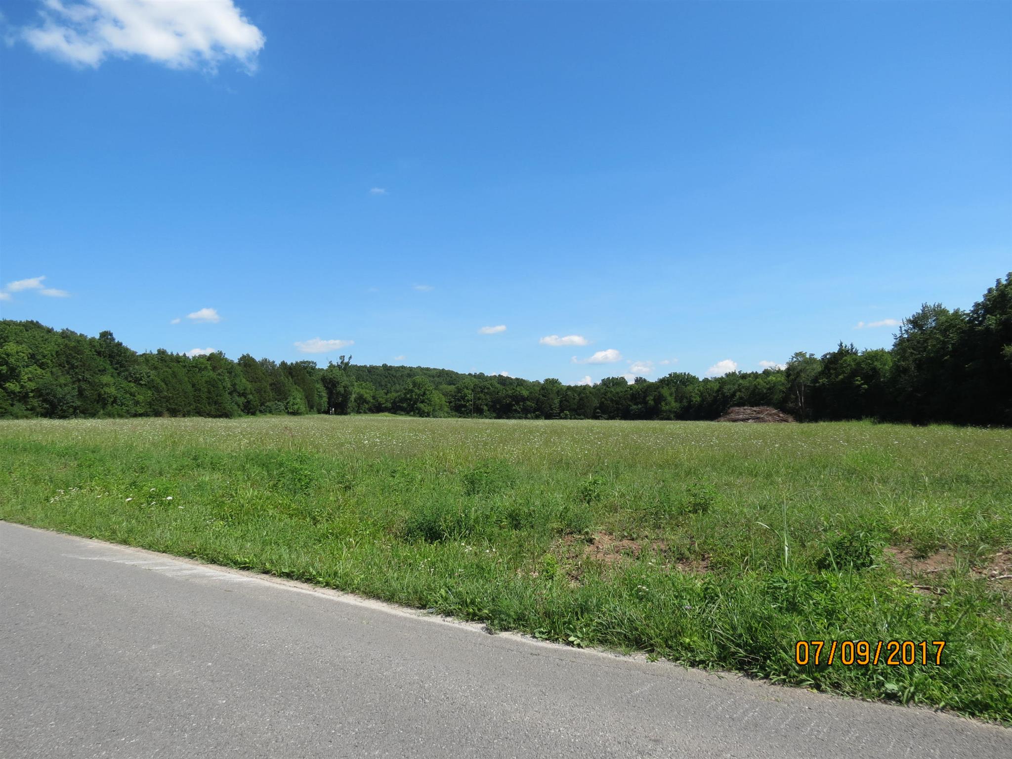 a view of a green field with wooden fence