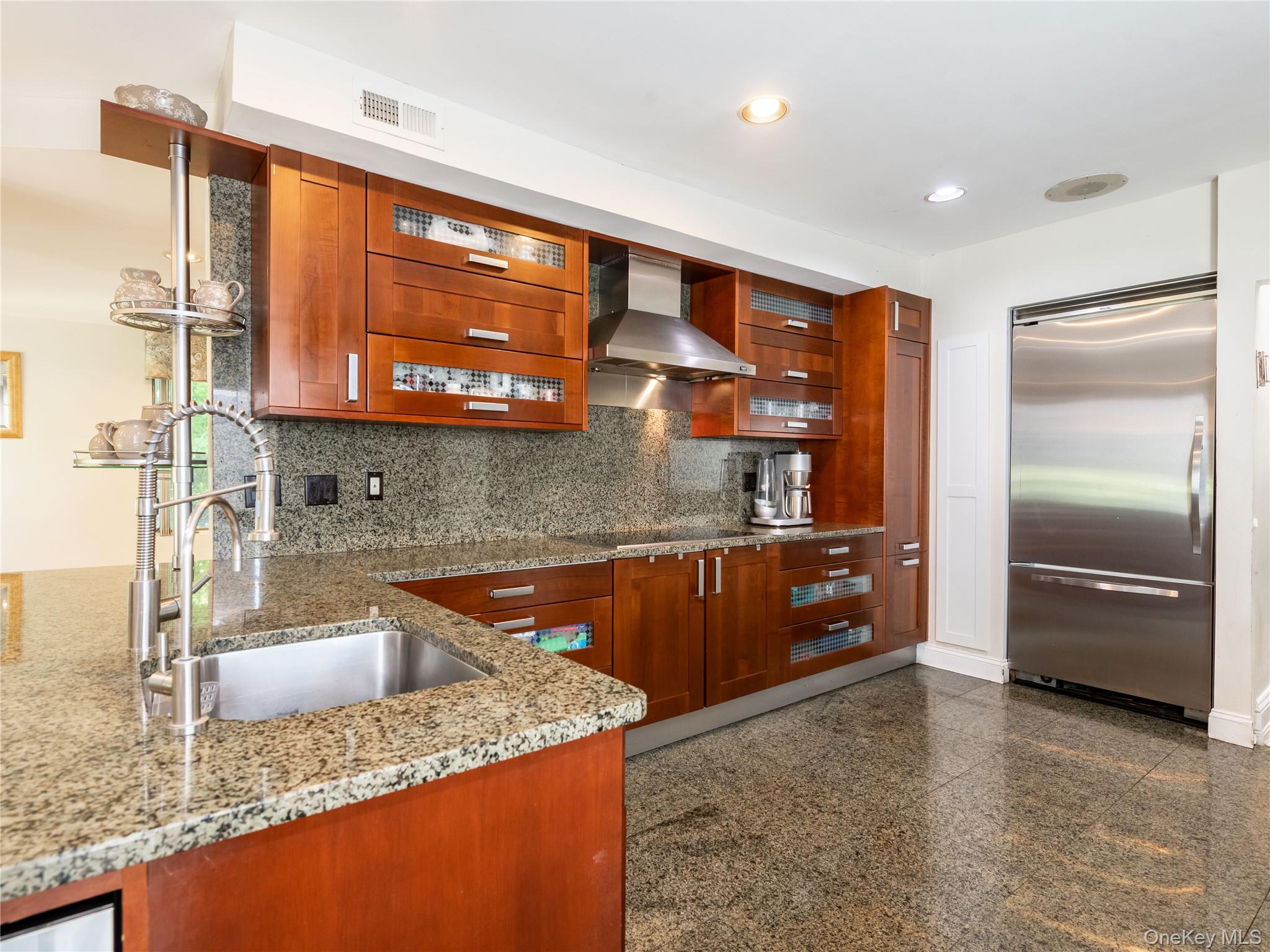 100 Station Road Great Neck, NY 11023 - Photo 12 of 29 a kitchen with stainless steel appliances granite countertop a sink and a refrigerator