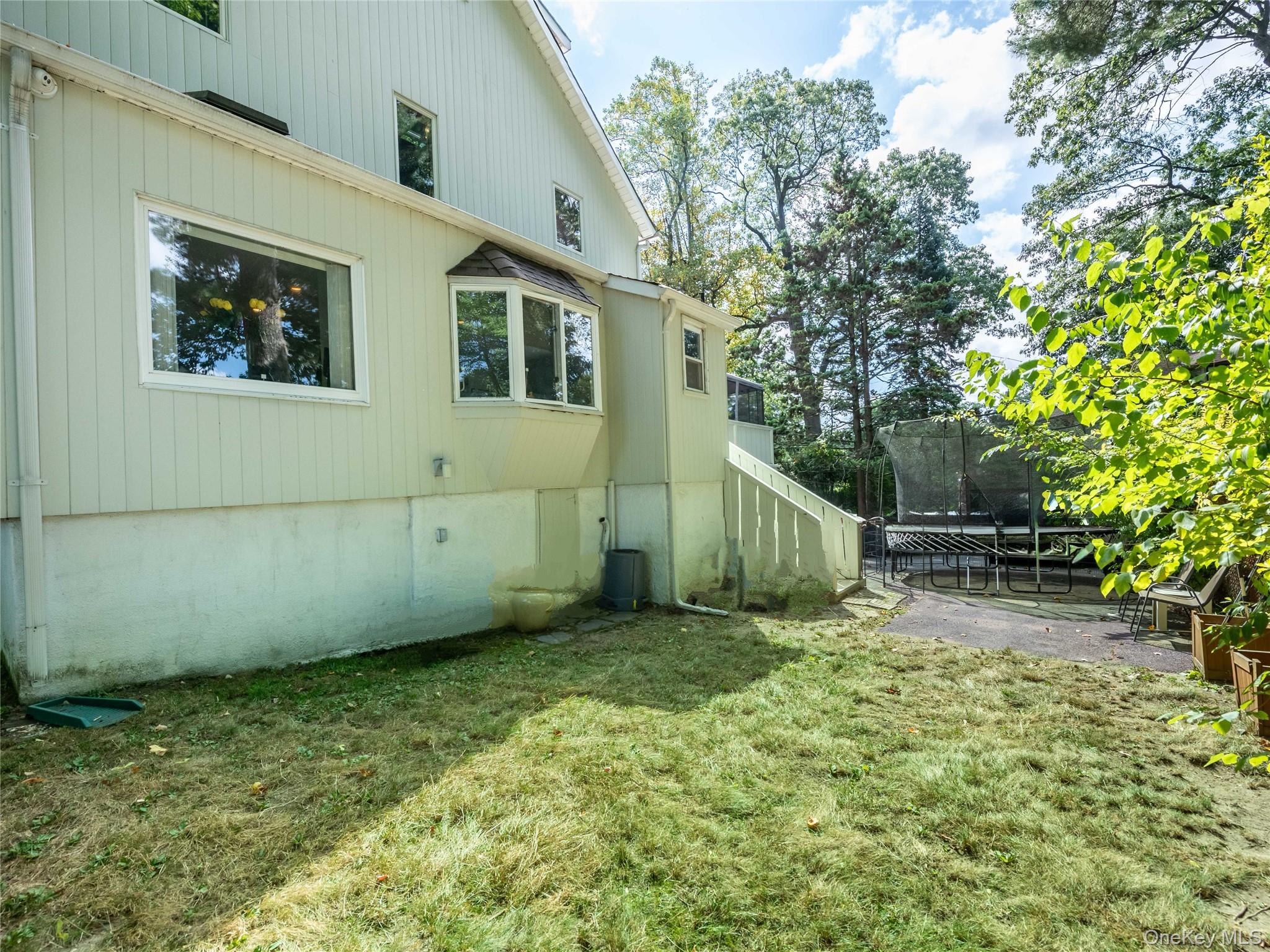 100 Station Road Great Neck, NY 11023 - Photo 25 of 29 a view of a house with a small yard and trees