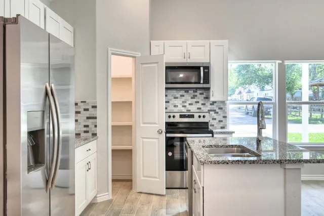 a kitchen with stainless steel appliances granite countertop a refrigerator and a stove