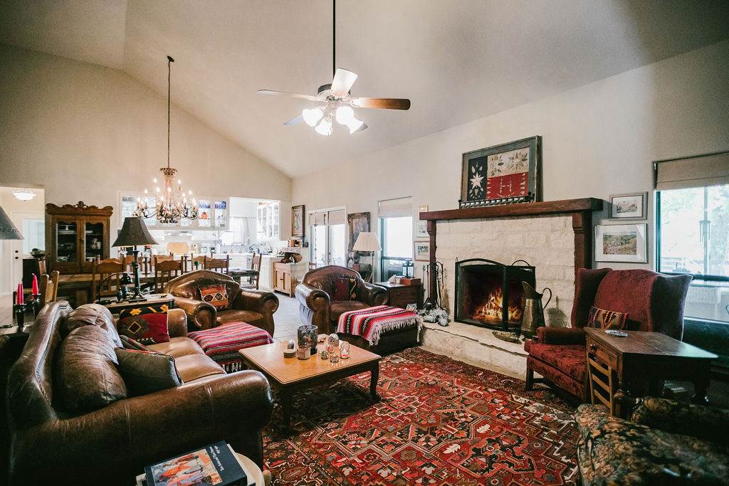 375 Co Road Uvalde, TX 78801 - Photo 19 of 30 a living room with furniture a fireplace and a chandelier