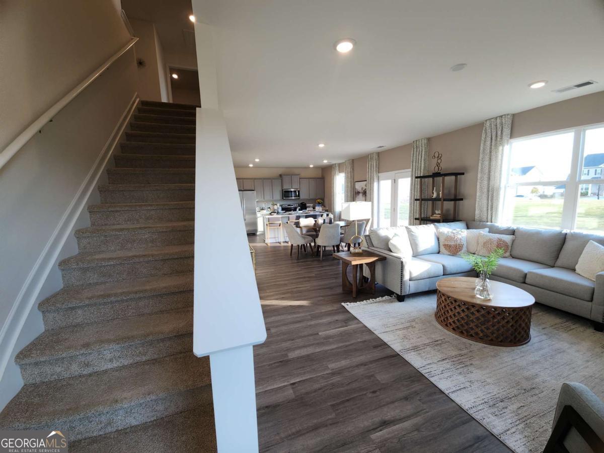 191 Aster Avenue Locust Grove, GA 30248 - Photo 11 of 28 a living room with couches and kitchen view with wooden floor