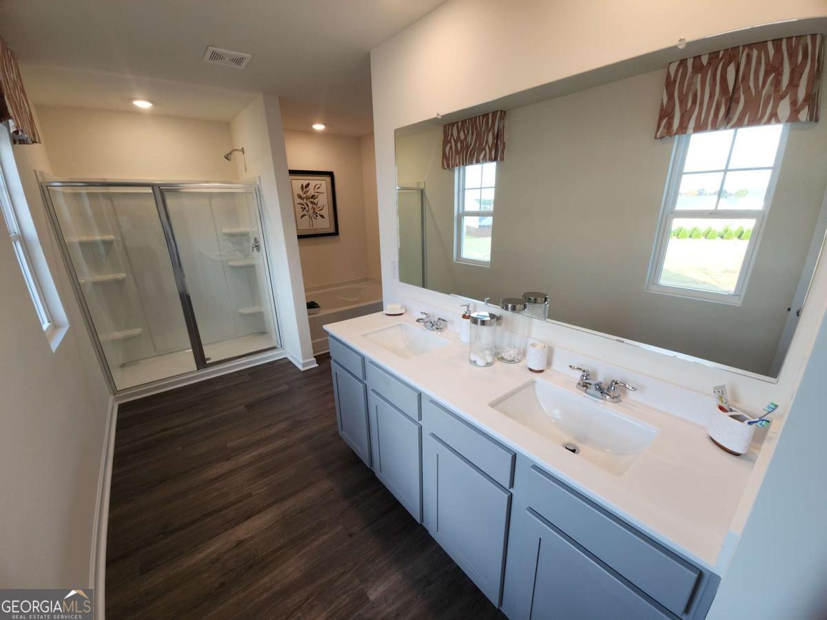 191 Aster Avenue Locust Grove, GA 30248 - Photo 17 of 28 a spacious bathroom with double vanity and a mirror