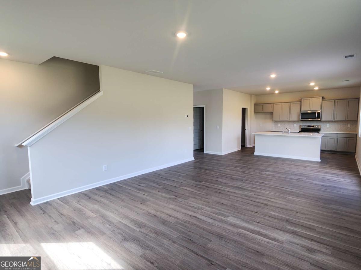 191 Aster Avenue Locust Grove, GA 30248 - Photo 23 of 28 a view of a big room with wooden floor and windows