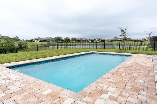 an aerial view of a house with a garden and lake view