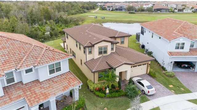 a aerial view of a house with a yard and lake view