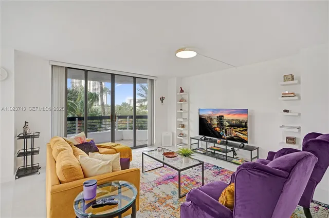 a living room with furniture a flat screen tv and a floor to ceiling window