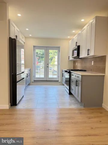 a large kitchen with stainless steel appliances granite countertop a stove and a refrigerator