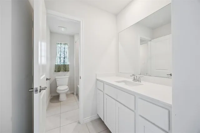 a spacious bathroom with a toilet sink and mirror