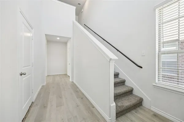 a view of entryway and hall with wooden floor