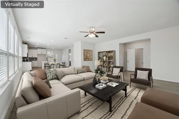 a living room with furniture kitchen view and a window