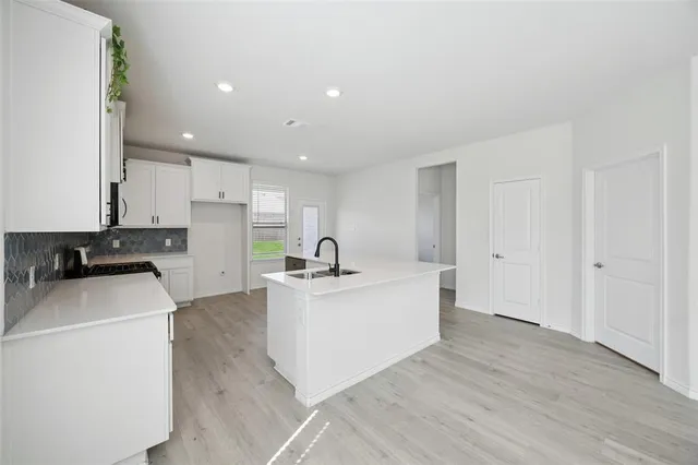 a large white kitchen with sink stove and refrigerator