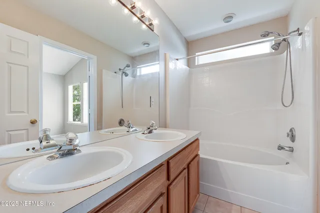 a bathroom with a tub sink shower and mirror