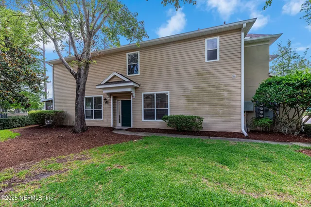 a front view of a house with a garden and yard
