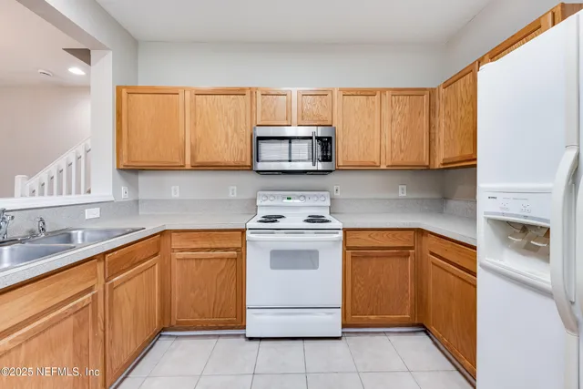a kitchen with stainless steel appliances granite countertop a sink stove and microwave