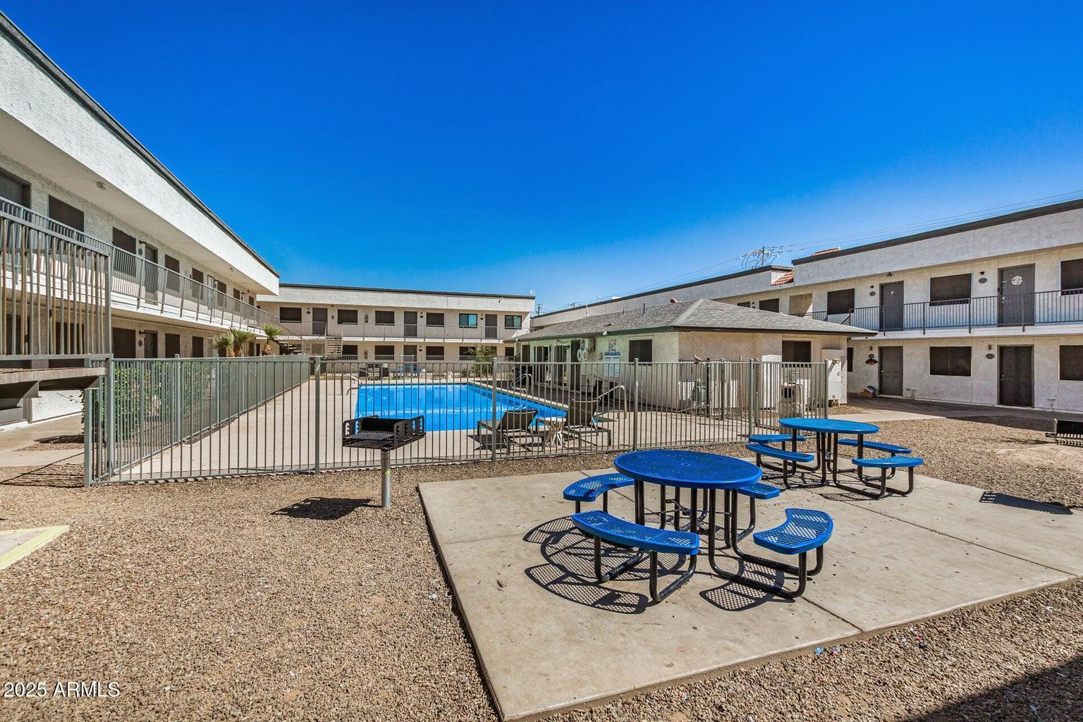 18202 North Cave Creek Road, Unit 209 Phoenix, AZ 85032 - Photo 12 of 12 a view of a patio with couches table and chairs with wooden floor and fence