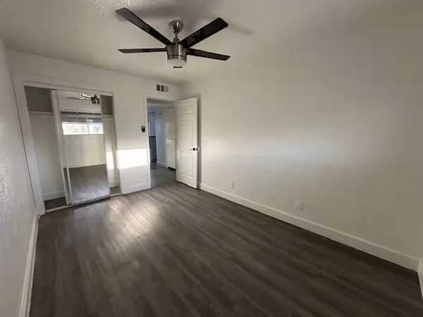 a view of empty room with wooden floor and window