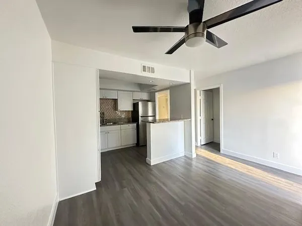 a view of a kitchen with a sink and dishwasher a refrigerator with wooden floor