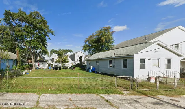 a view of a white house with a yard and plants