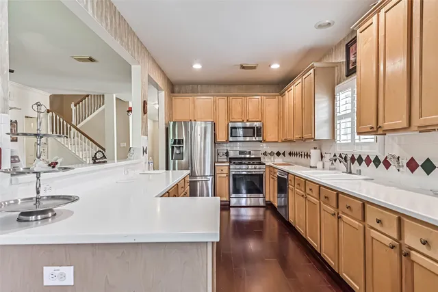 a kitchen with stainless steel appliances a sink a stove and a refrigerator