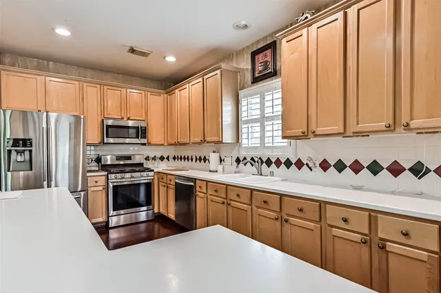a kitchen with stainless steel appliances granite countertop a refrigerator sink and cabinets