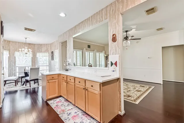 a large white kitchen with a stove a sink dishwasher and a refrigerator with wooden floor