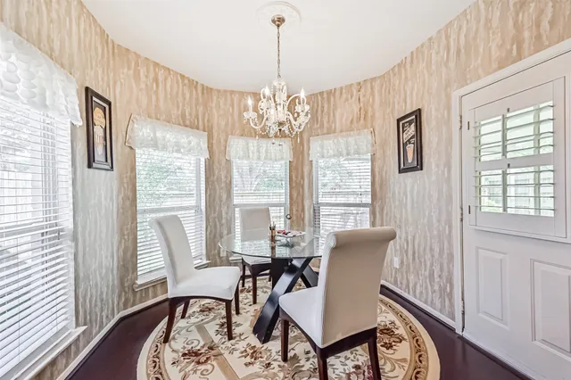 a view of a dining room with furniture wooden floor and a chandelier