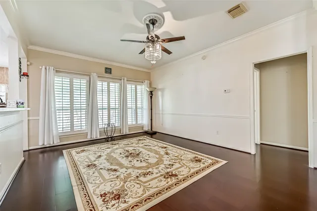 a view of an empty room with window and wooden floor