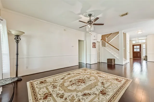 a view of a hallway with wooden floor and chandelier