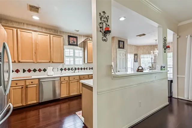 a kitchen with stainless steel appliances white cabinets and wooden floors