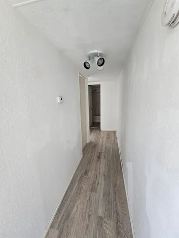 a view of a hallway with wooden floor