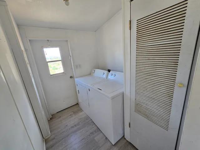 a utility room with wooden floor washer and dryer