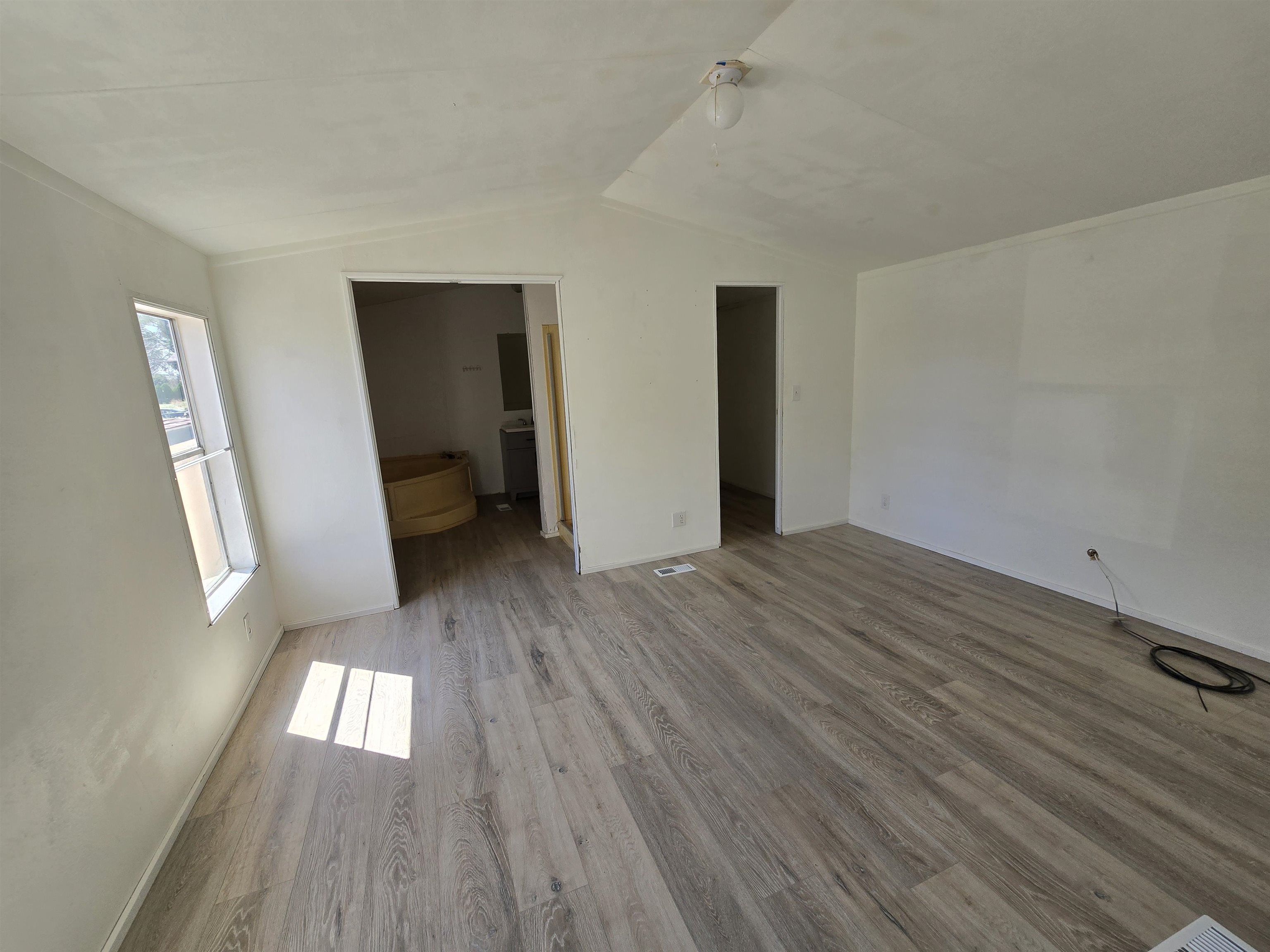 675 1/2 24 1/2 Road Grand Junction, CO 81505 - Photo 3 of 25 an empty room with wooden floor and windows