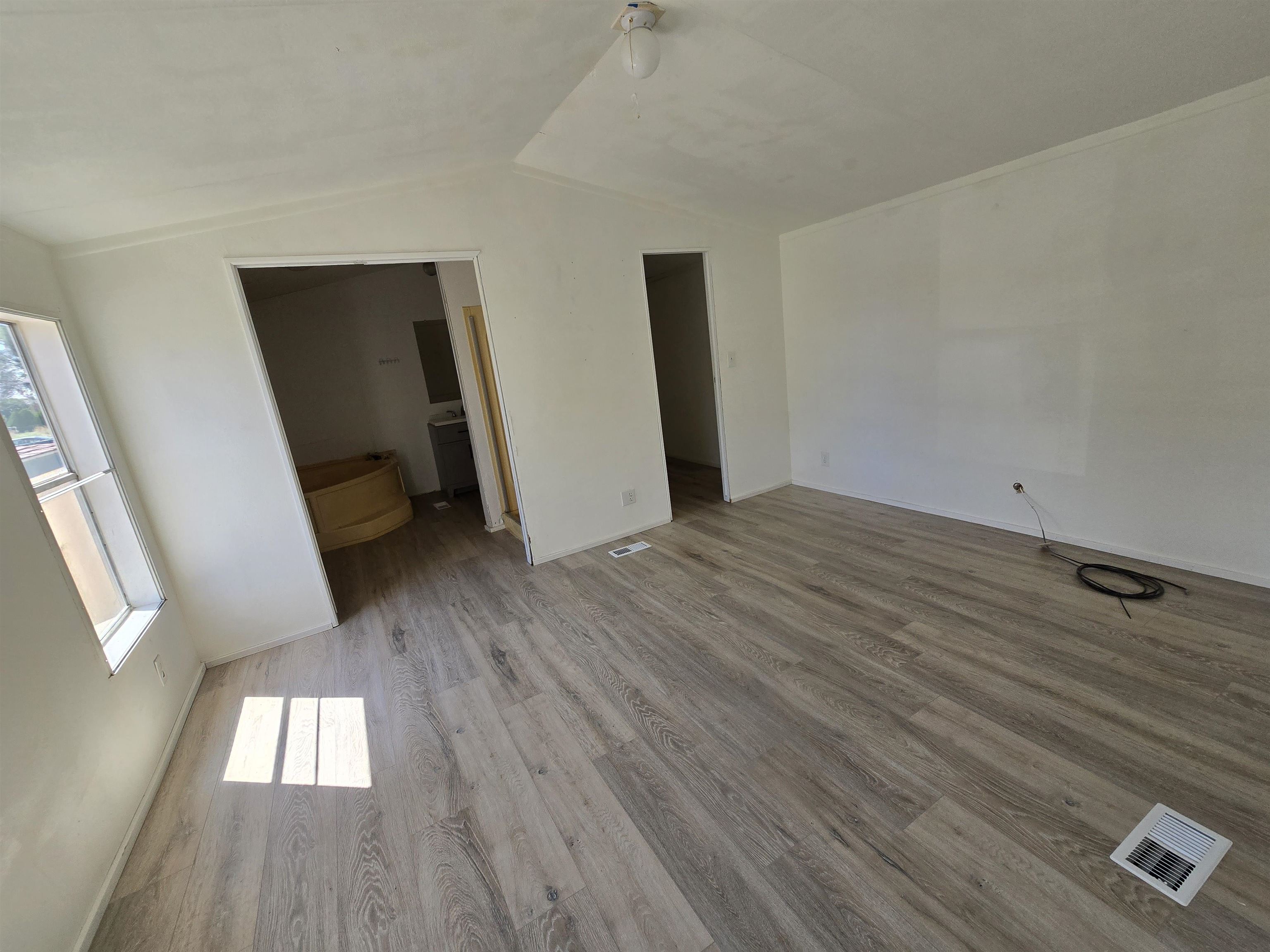 675 1/2 24 1/2 Road Grand Junction, CO 81505 - Photo 4 of 25 a view of an empty room with wooden floor and a window