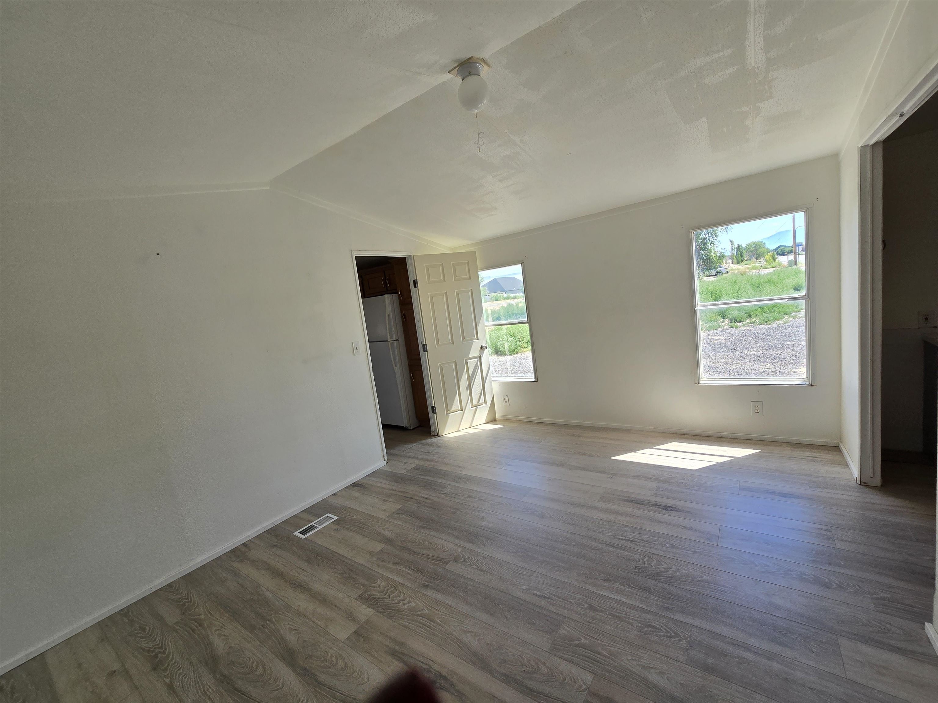 675 1/2 24 1/2 Road Grand Junction, CO 81505 - Photo 5 of 25 an empty room with wooden floor and windows