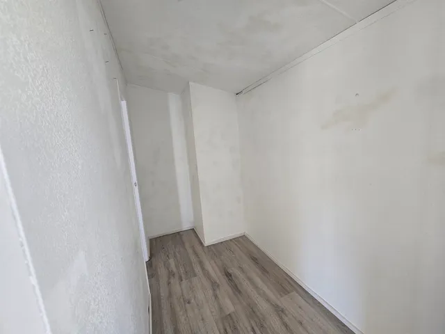 a view of a room with wooden floor