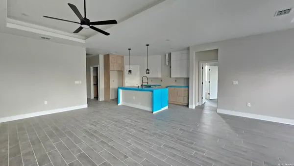 a view of a kitchen with wooden floor and a refrigerator