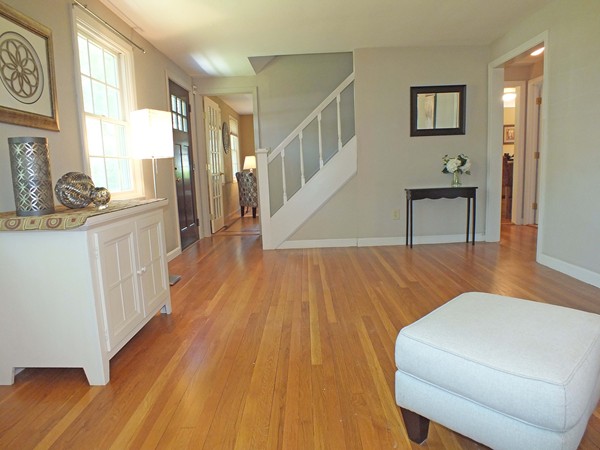 7 Conestoga Road Chelmsford, MA 01824 - Photo 9 of 29 a hallway with a dining table chairs wooden floor and a large window