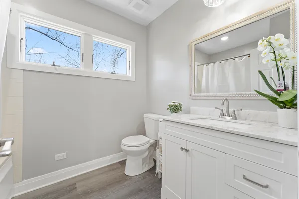 a bathroom with a granite countertop sink mirror vanity and toilet
