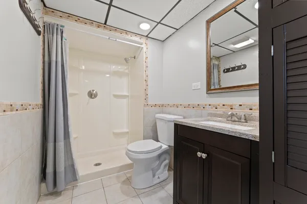 a bathroom with a granite countertop sink toilet and shower