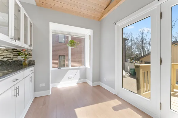 a view of a hallway with wooden floor and windows