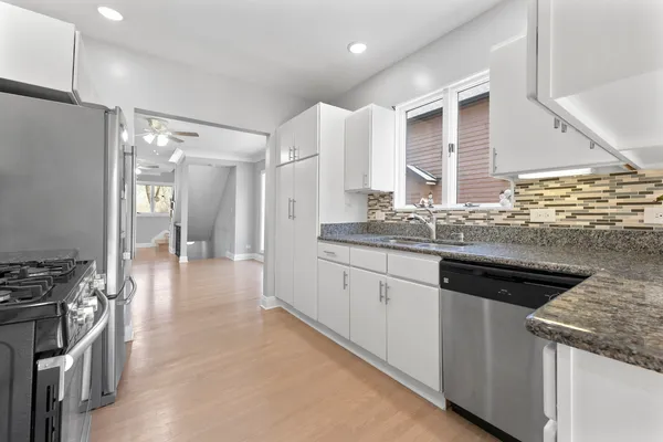 a kitchen with stainless steel appliances granite countertop a sink and a stove